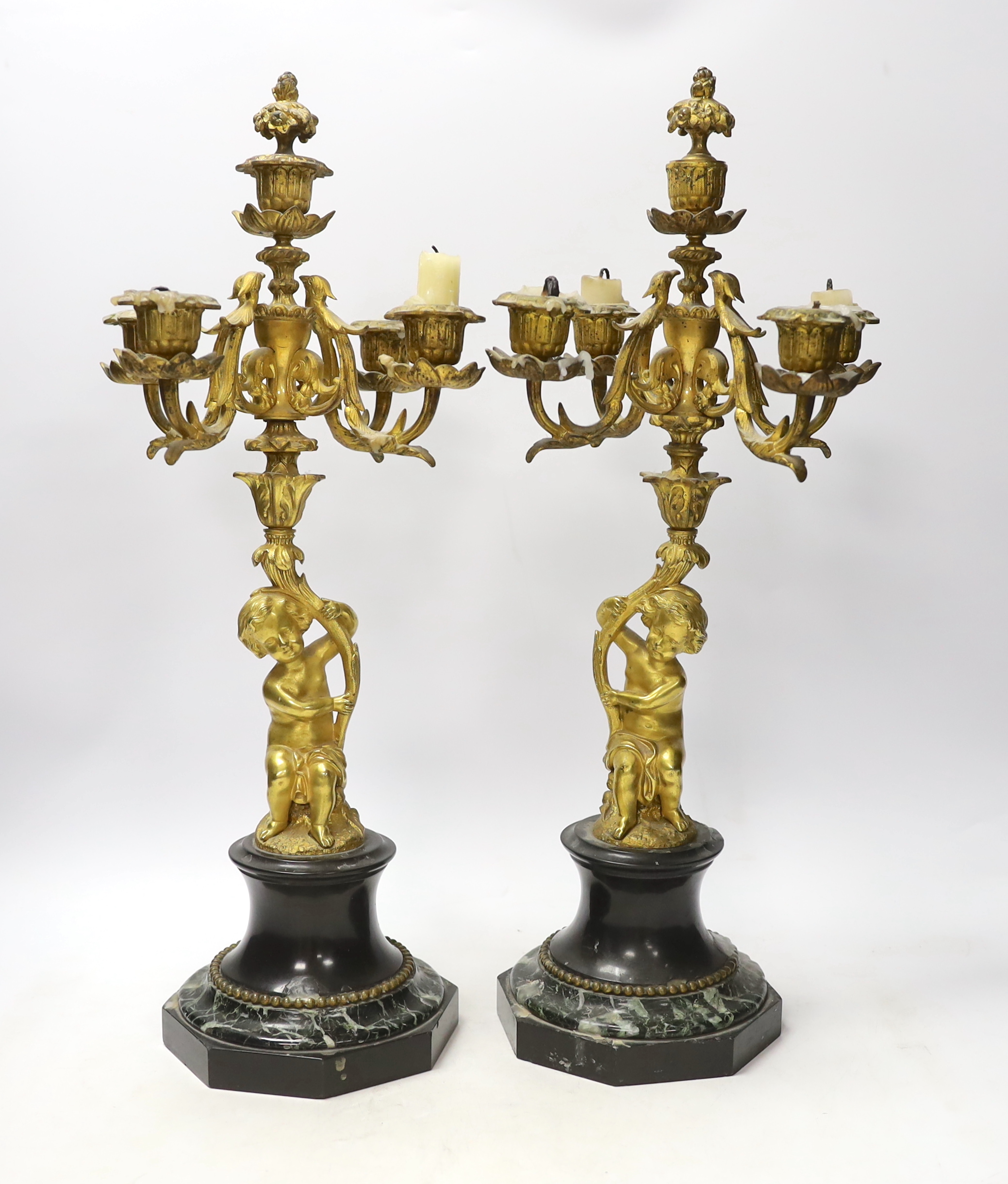 A pair of late 19th century French ormolu cherubic four branch candelabra on marble bases, 47cm